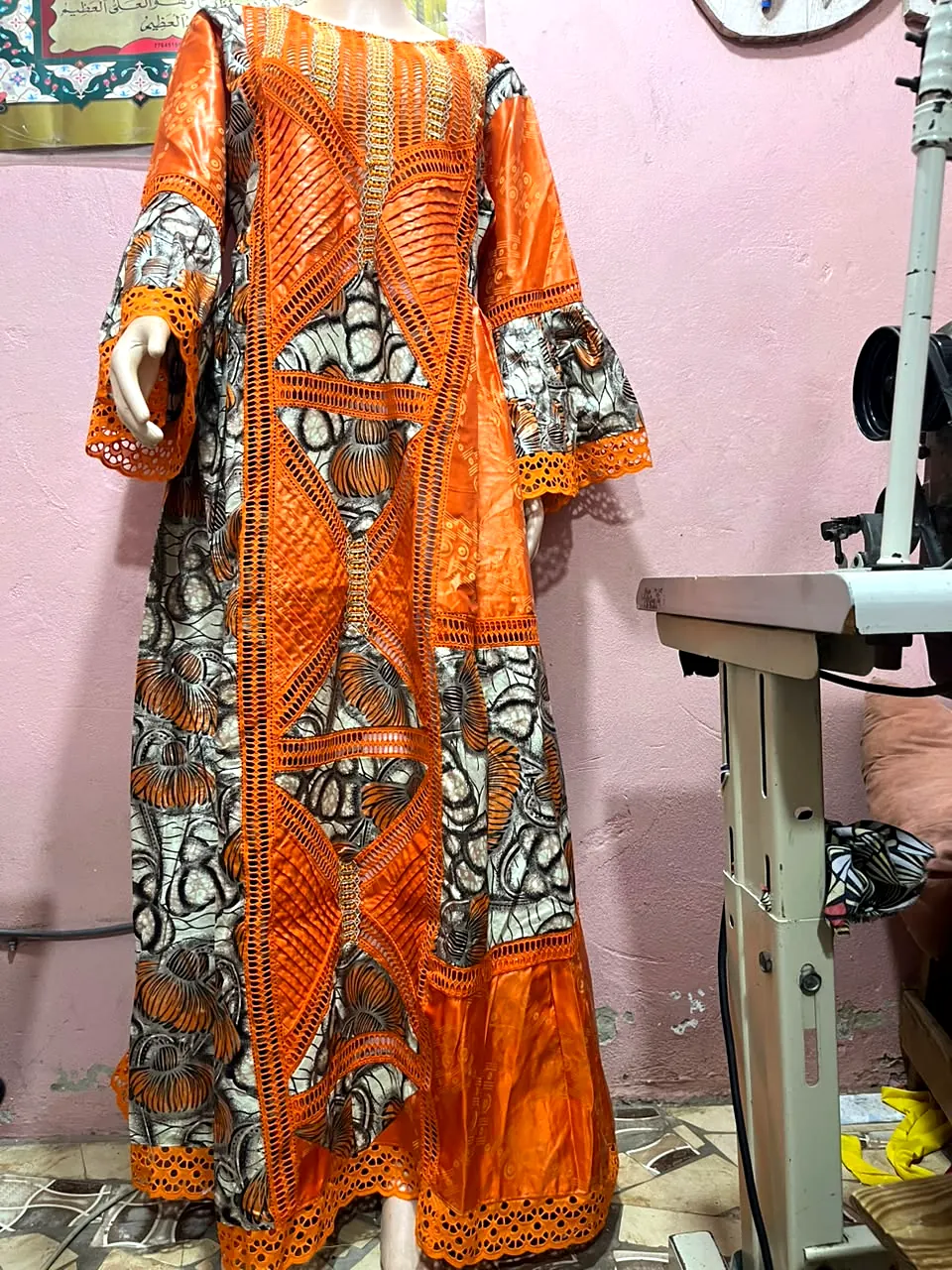 Robe longue orange avec imprimé, bandes ajourées et dentelle, présentée sur mannequin