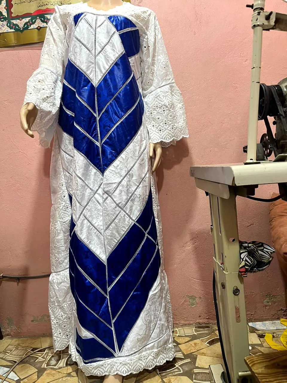 Robe longue blanche brodée avec panneau central à chevrons bleu roi, présentée sur mannequin